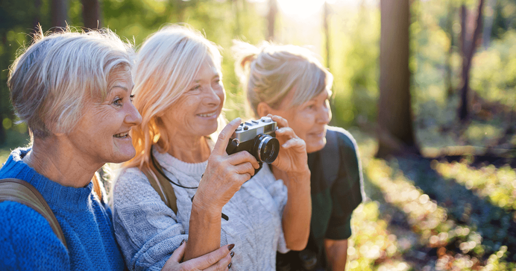 Three women looking into the distance at nature with a camera