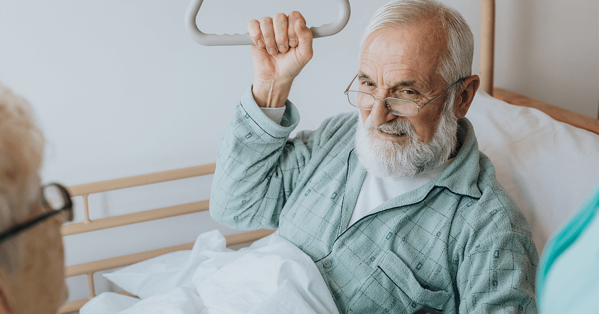 an immobilized elderly man in bed speaking with a family member who will treat his skin infection