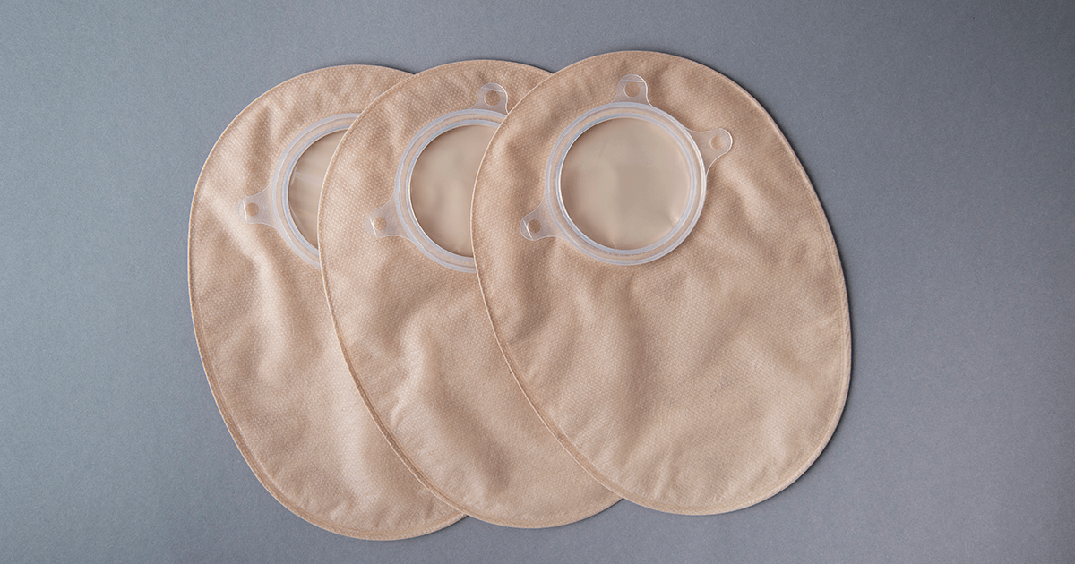 three ostomy bags on a grey background