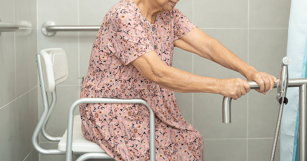 Woman sitting on a transfer bench in the bathroom